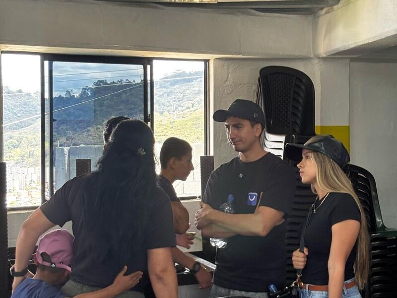 Miembros del equipo de LucidBot conversan con personas de la fundación en un salón con vista a la montaña.